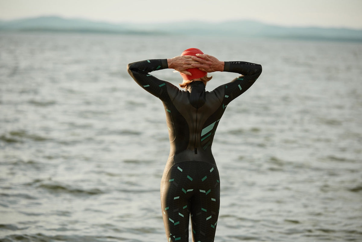 Woman stretching before swimming in a lake